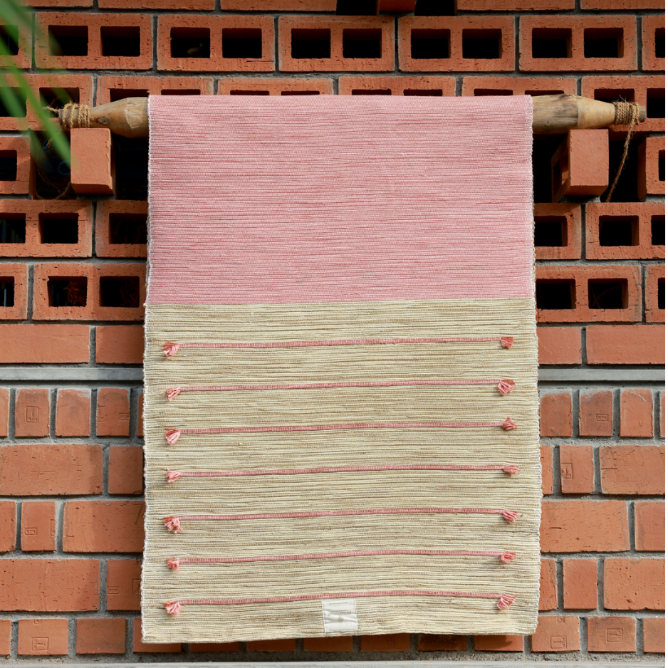 Ayurvedisch gefärbte Surya Rose Yogamatte in natürlichen Rosa- und Goldtönen an einer indischen Wand